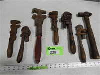 Antique pipe wrenches and a hammer