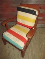 Rustic upholstered arm chair and camp blankets.