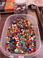Two containers of marbles including shooters,