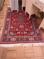 Wool fringed rug, red ground with floral