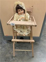 Porcelain doll in doll sized wood highchair