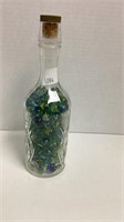 Glass bottle with flower design full of marbles