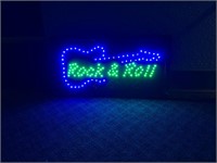 Light up sign, says "Rock and Roll" with a guitar