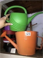 Small plastic and metal watering cans, buckets
