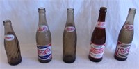 Vintage dark Pepsi bottles.