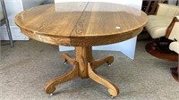 Laminated top round oak dining table, on wheels,