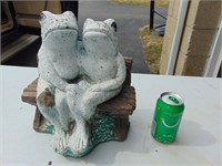 concrete frogs on bench