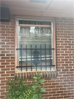 Wrought iron window panel back right of house