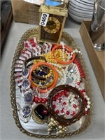 Vintage costume jewelry on mirror tray
