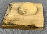 Adorable ivory carving of a sleeping fox on a beve