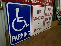 Three metal parking signs. A blue handicapped