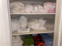 Closet of bedding mostly sealed in bags