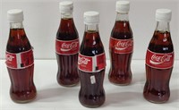 5 Full Glass Coca Cola Bottles w/ Lids