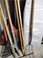 Ironing board, rakes, post hole digger, pitchfork