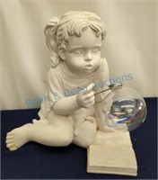 Girl sitting on floor blowing bubbles statue