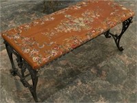 Antique cast iron bench with patterned upholstered