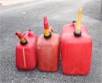 Three gas cans, two 2 gallon & one 5 gallon,