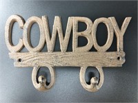 Brand new cast iron double wall hook that says "CO
