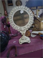 Tilting cast metal pedestal vanity mirror.