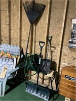 Lawn tools and a hose and a stand