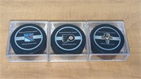 3 Various Official NHL Hockey Pucks in Case