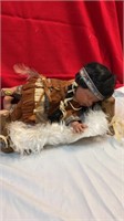 Native American doll on wood bed