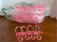 Large bag of pink pacifier baby shower decor