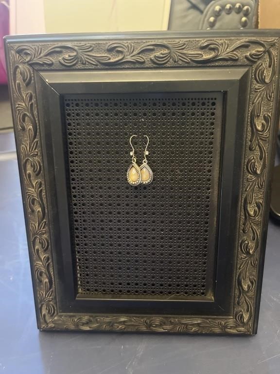 Earrings and a metal frame to display them