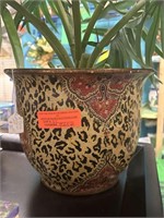 Faux palm in decorative leopard style pot.
