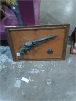 Group of wall art.   A framed pistol with star