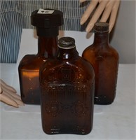 3 amber liquor bottles