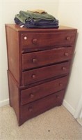 Five drawer wood dresser with various bathroom