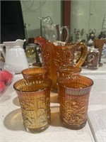 Carnival glass pitcher & cups