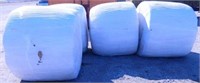 (4) round bales of wrapped hay