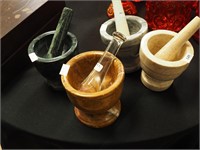 Four stone mortars and pestles in various colors