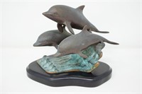 Brass dolphin on wave sculpture