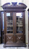 Henri II Style Mascaron Crowned Walnut Bookcase.