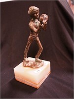 Metal statue of a boy holding a glass globe on