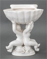 White Porcelain Shell Form Coupe Atop Two Cherubs
