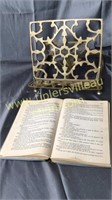 Brass book stand with vintage copy of little