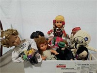 A box of several dolls different sizes and types