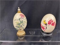 Two hand-painted eggs on plynths