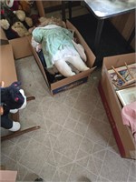 Boxes of toys and dolls on floor