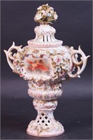 A 12" high figural lidded urn decorated with