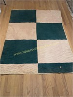 Green and brown hand made quilt has toe hole and