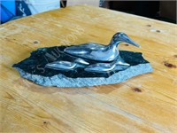 Silver ducks on marble pond