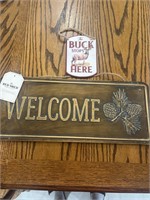 Signs “welcome” and “the buck stops here”