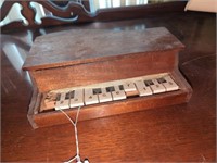 Vintage miniature wooden toy piano has some