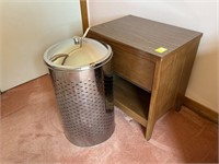 Stainless steel hamper and a small bedside stand.