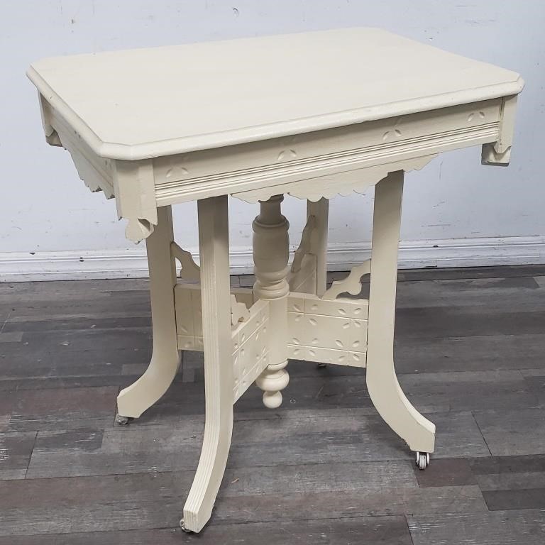 Painted carved wood table on casters